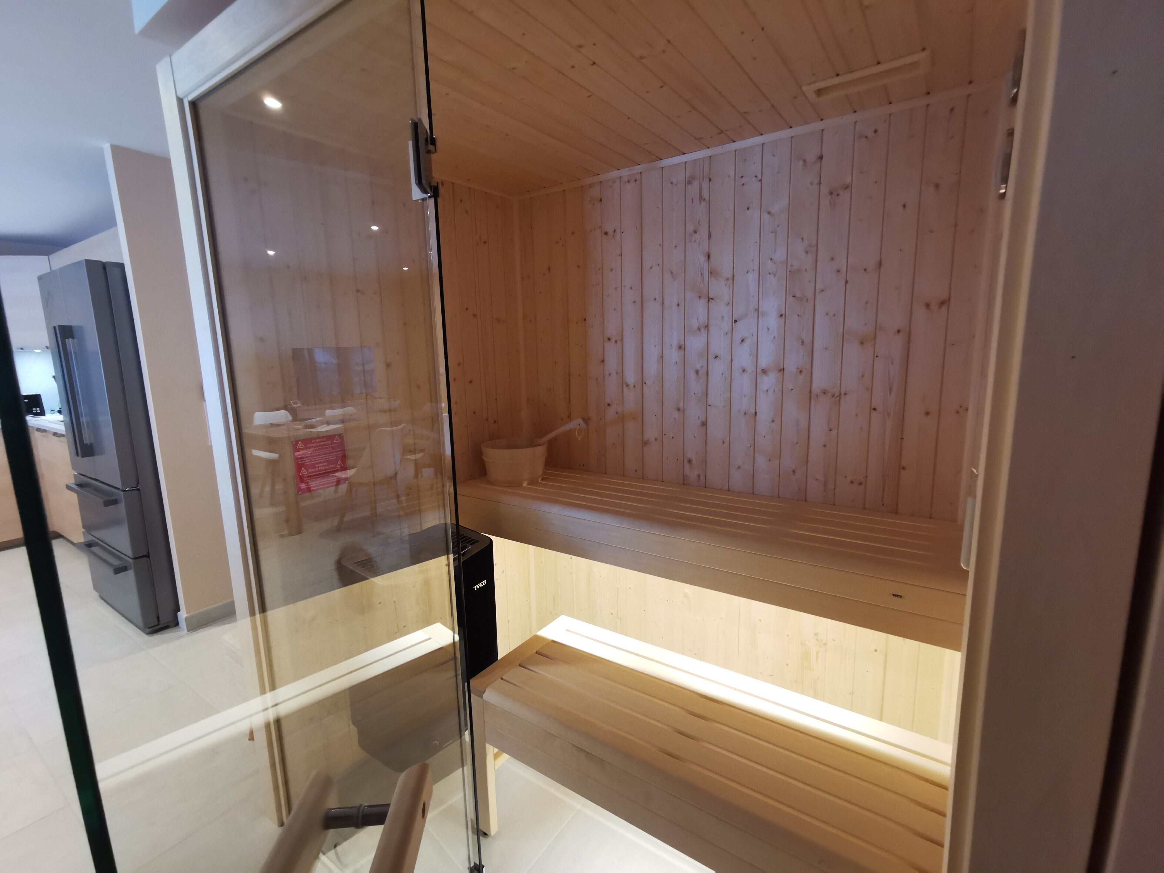 A sauna room with wooden walls and benches.