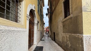 A narrow alleyway with buildings on either side, featuring arched doorways and windows with shutters. - Lux Lodge near Piazza Erbe (Verona)