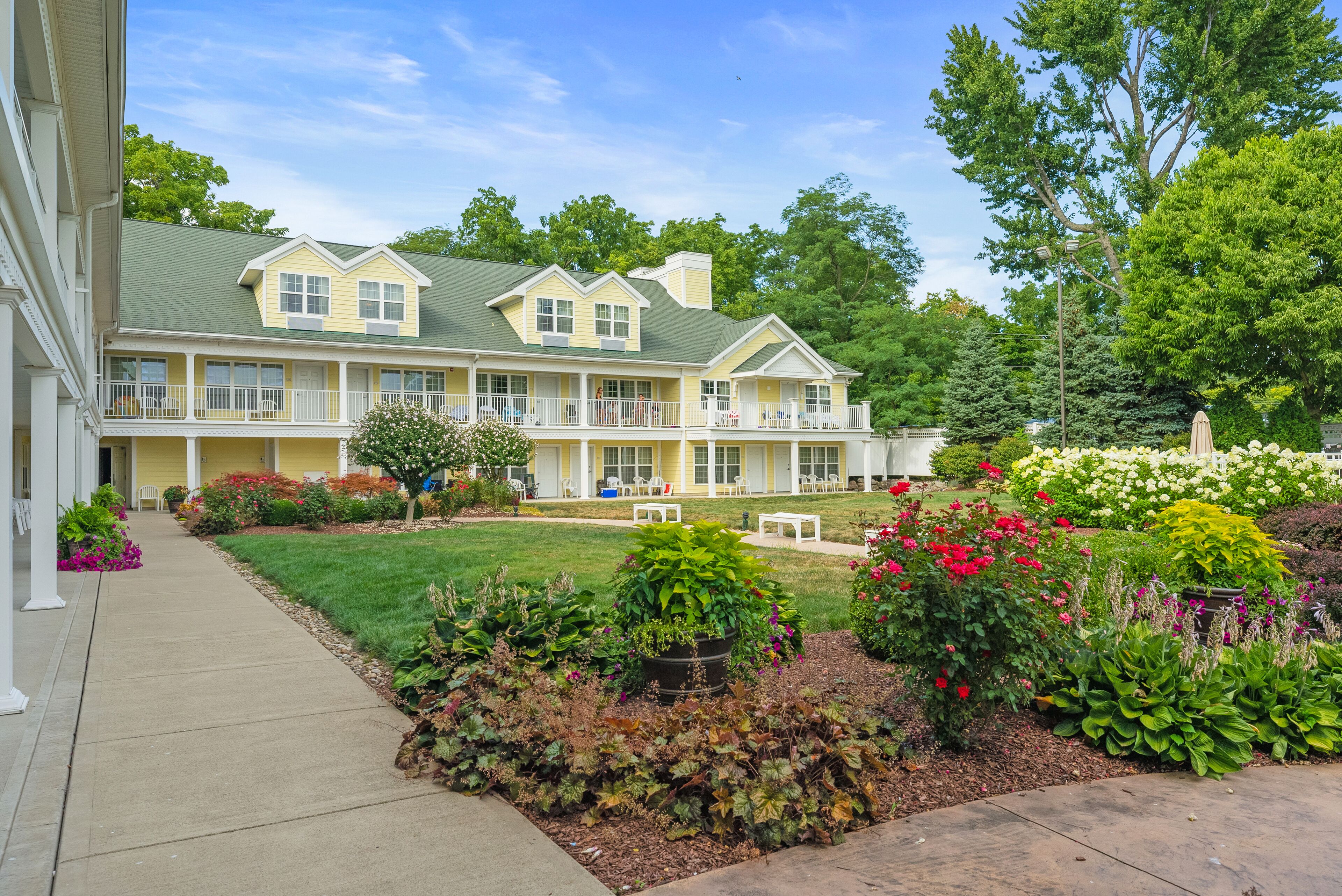 A two-story building with a covered porch and a well-maintained garden.