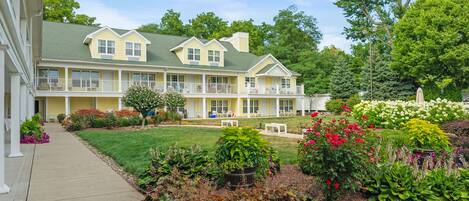 A two-story building with a covered porch and a well-maintained garden.