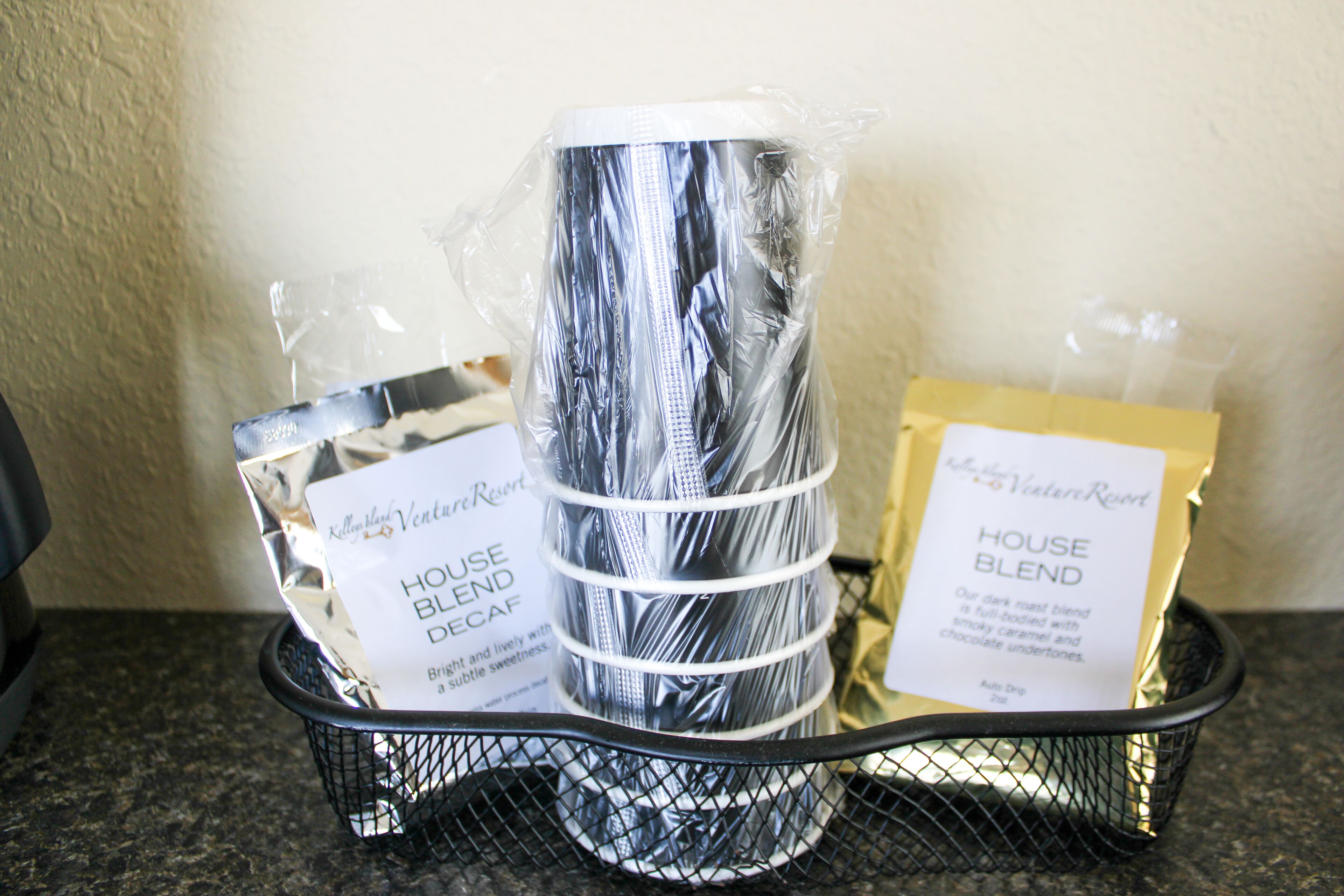 A basket containing a package labeled "House Blend Decaf" and another labeled "House Blend."