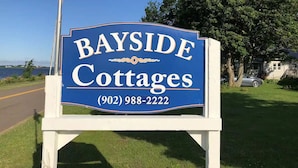 Naamplaatje voor Bayside Cottages met telefoonnummer.