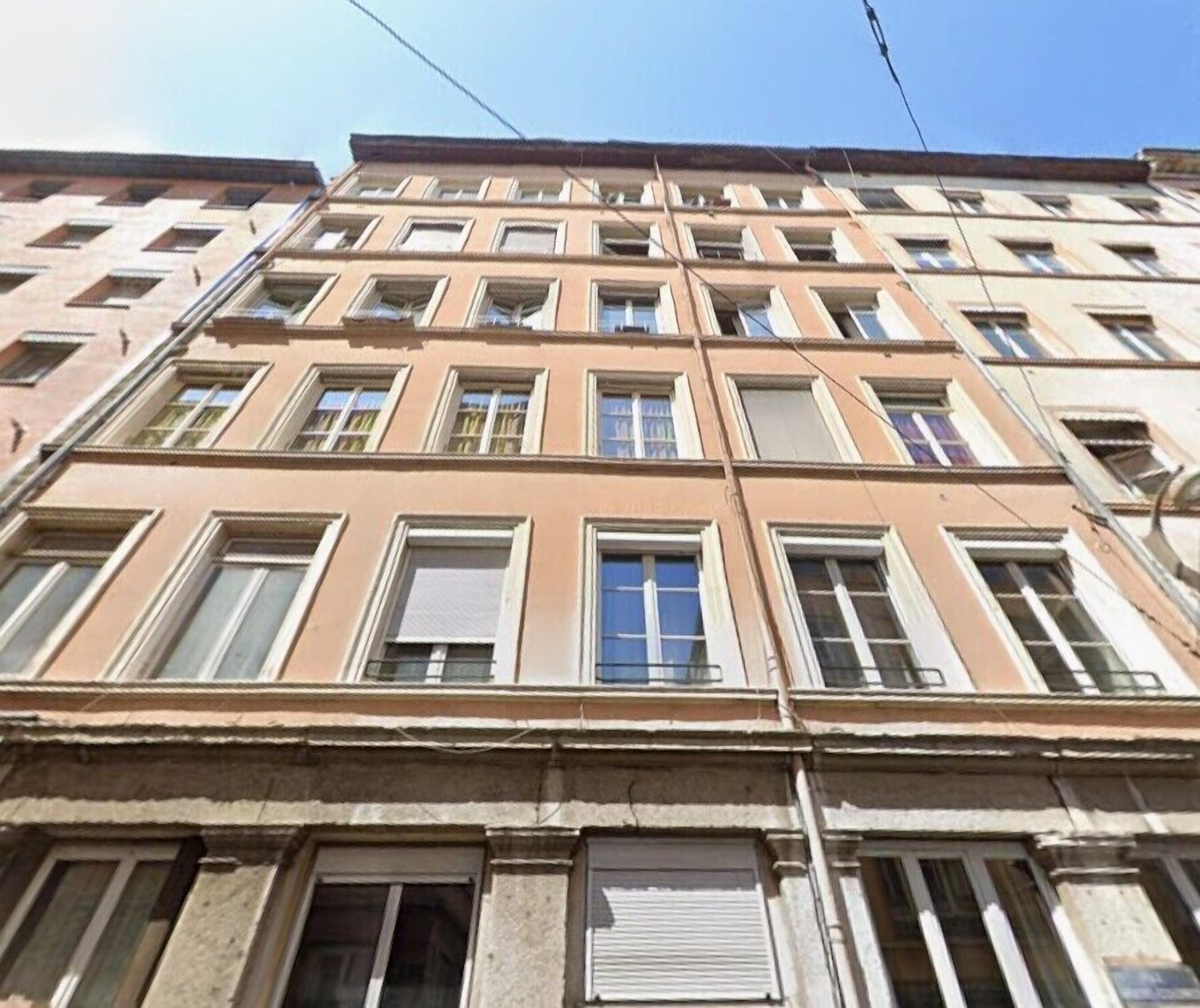 Un edificio a più piani con uno stile architettonico uniforme, caratterizzato da una serie di finestre e balconi.
