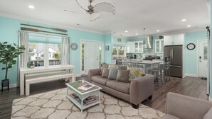 Un salon moderne comprenant un canapé, une table basse et un coin repas avec des chaises.