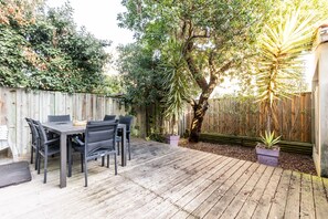A wooden deck with a table and chairs, surrounded by a wooden fence and various plants. - Apartment 'Cap-ferret Phare Ref 130' with Private Terrace (Lège-Cap-Ferret)