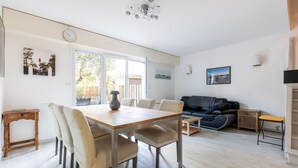 A modern living room with a dining area, a sofa, and a TV. - Apartment 'Cap-ferret Phare Ref 130' with Private Terrace (Lège-Cap-Ferret)