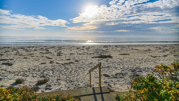 A beach with footprints, a flag, and a clear sky. - Private access to the beach! Sleeps 9. (Wells)