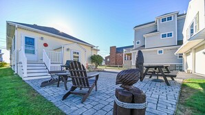 A patio area with a wooden Adirondack chair, a picnic table, and a decorative wooden sculpture. - Private access to the beach! Sleeps 9. (Wells)
