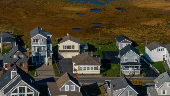 A residential area with houses, a street, and a grassy field with ponds.
