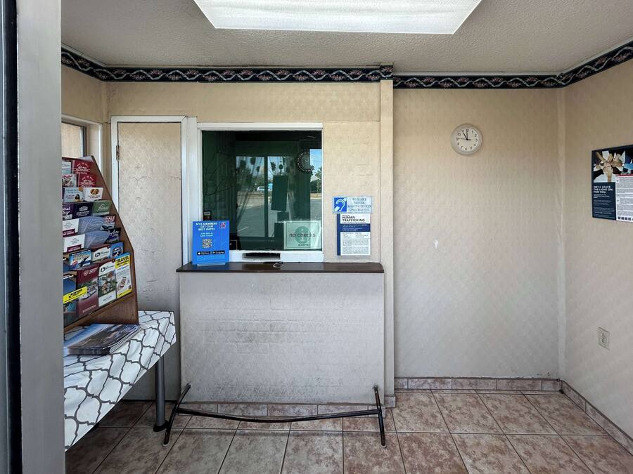 Uma área de recepção com balcão, relógio e janela.