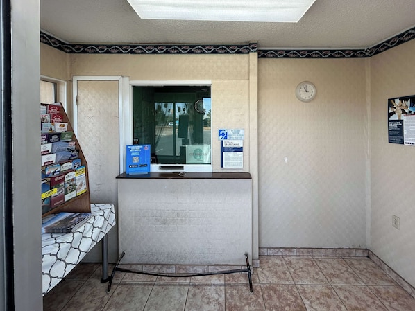 Un área de recepción con mostrador, reloj y ventana.