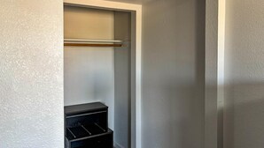 A corner of a room with a white wall and a black storage unit with drawers.