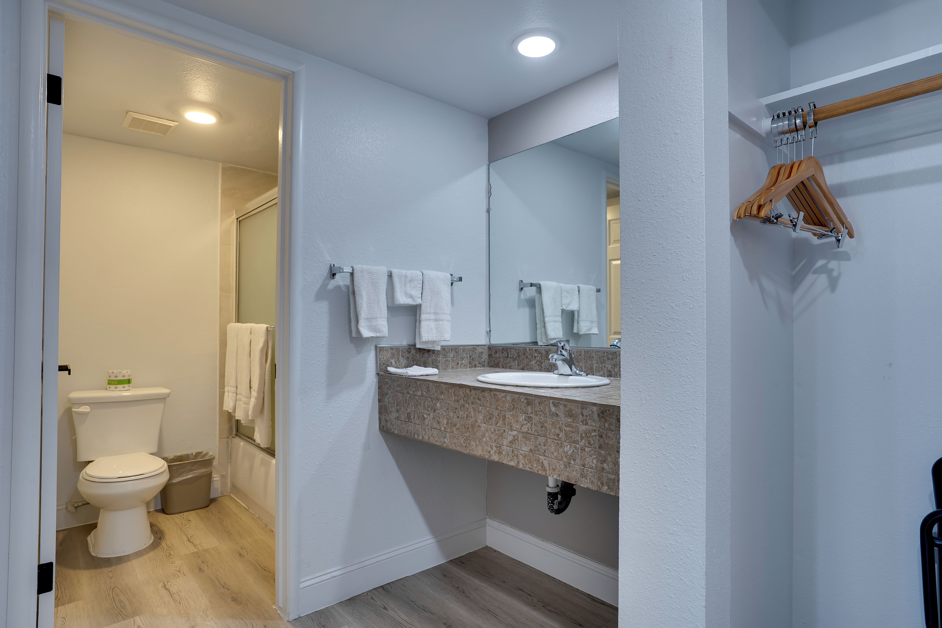 Une salle de bain équipée d’un WC, d’un lavabo, d’un miroir et d’un porte-serviettes.