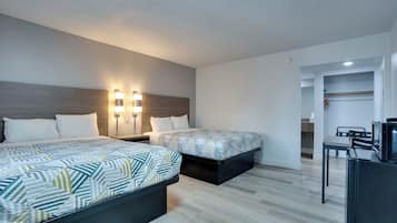 Une chambre d’hôtel avec deux lits, un bureau et une télévision.