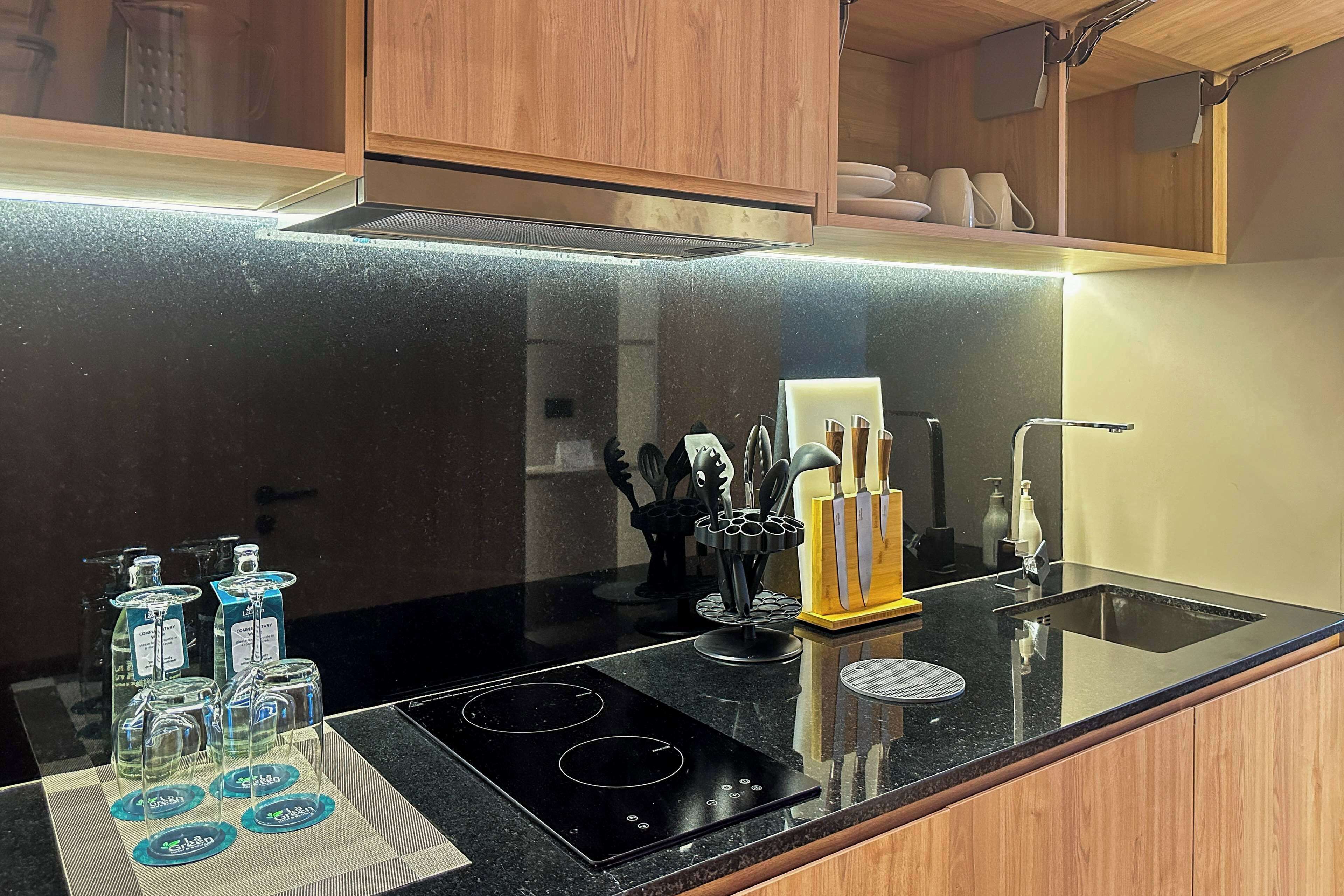 Una cocina moderna con encimera negra, electrodomésticos de acero inoxidable y armarios de madera.