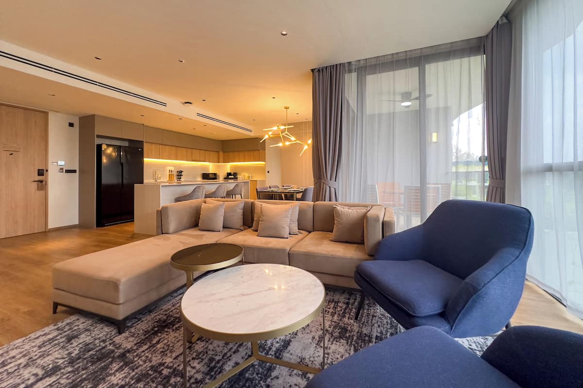 A modern living room with a sofa, armchairs, and a round coffee table.