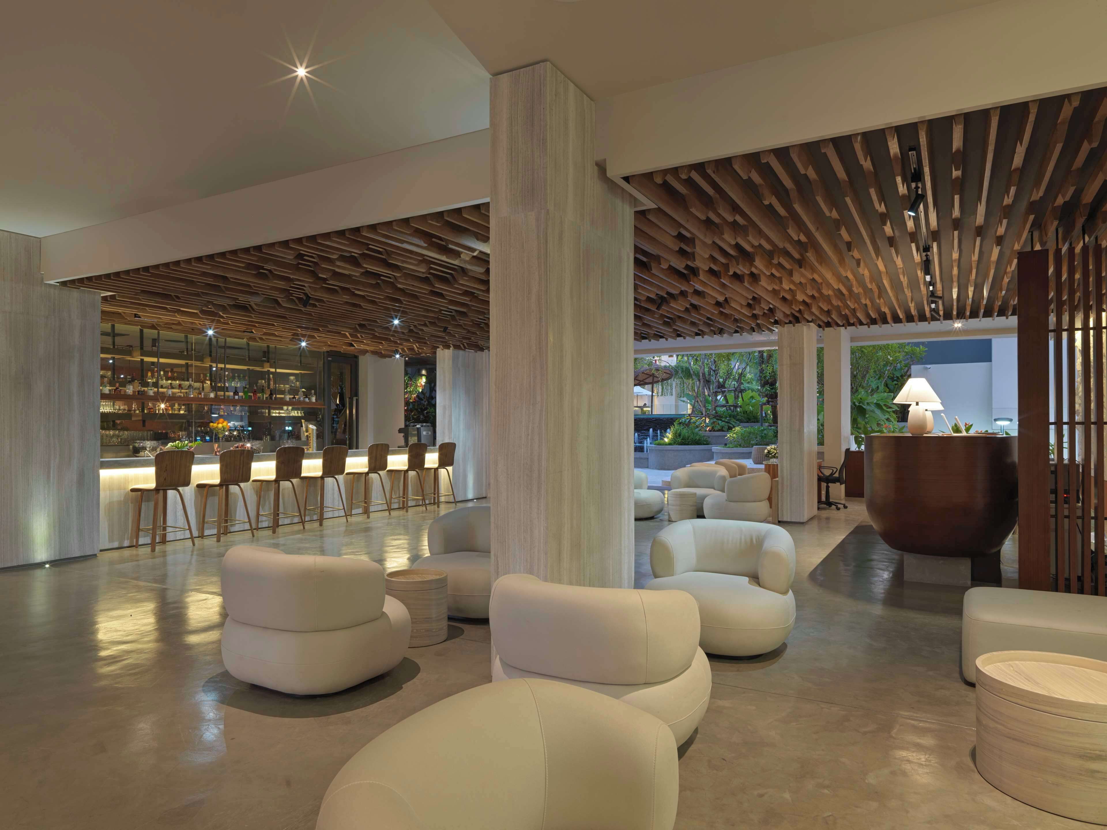 A modern interior with a bar area, seating, and a wooden ceiling design.