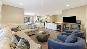 A modern living room with a sectional sofa, a round coffee table, and a TV.