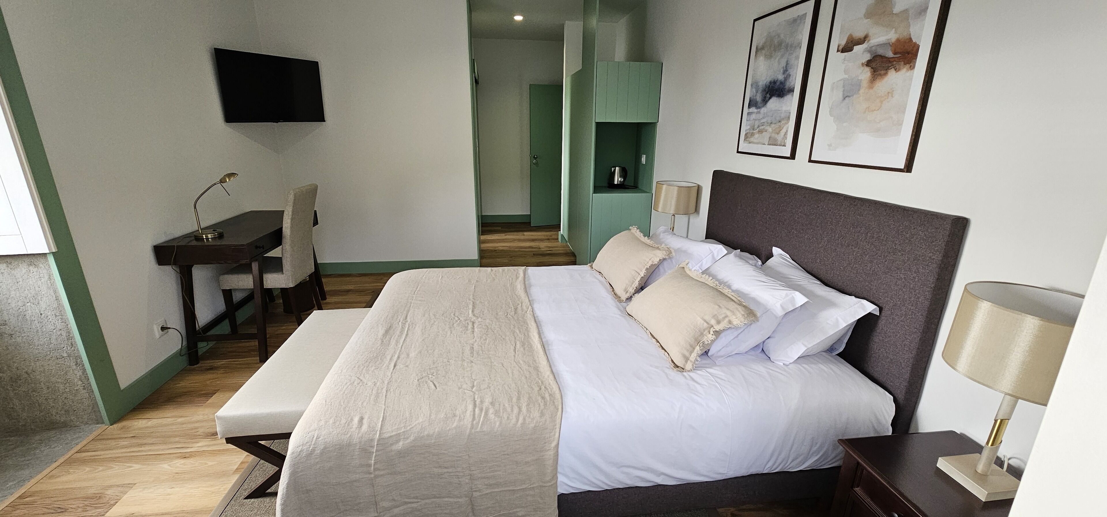 Une chambre bien rangée, avec un lit, une table de chevet, une lampe et un bureau avec une chaise.