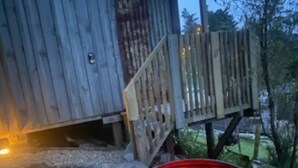 Una struttura in legno con un braciere in metallo in primo piano.