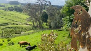 Un prato verde con una mucca e una recinzione.