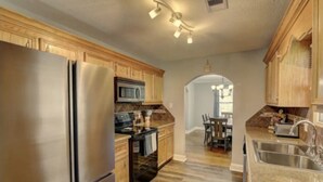 Una cocina moderna con electrodomésticos de acero inoxidable, armarios de madera y una isla central.