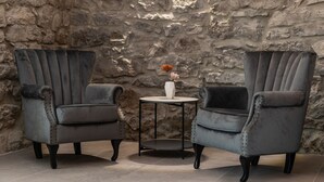 Two grey armchairs with a small round table and a vase between them, set against a stone wall. - Villa Angelica with heated pool (Kvarner - Lakmartin) (Lakmartin)
