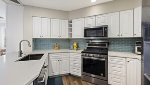 A modern kitchen with white cabinetry, a stainless steel range, a microwave, and a built-in oven. - SeaCrest ~N Forest Beach Coligny OCEANVIEW~HUGE 1 bedroom!  Top floor! POOL! Gym (Hilton Head Island)