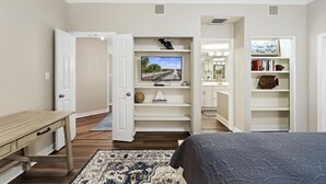 A bedroom with a bed, a desk, a TV on a shelf, and a bookshelf. - SeaCrest ~N Forest Beach Coligny OCEANVIEW~HUGE 1 bedroom!  Top floor! POOL! Gym (Hilton Head Island)