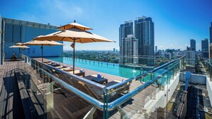 A rooftop pool area with lounge chairs and umbrellas, overlooking a cityscape with high-rise buildings. - Sofia Colombo City Hotel (Colombo)