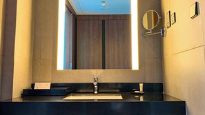 A modern bathroom with a large mirror, a sink, and a towel dispenser. - Sofia Colombo City Hotel (Colombo)