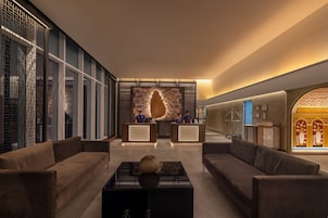 Un lobby moderno con mostrador de recepción, sofás y una pared decorativa.