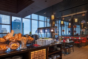 A restaurant with a buffet of bread and pastries, a coffee station, and traditional lanterns. - Sofia Colombo City Hotel (Colombo)