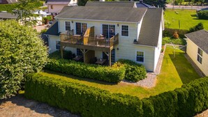 A two-story house with a balcony, surrounded by well-maintained hedges and a lawn. - Flaschenpost by Interhome (Zinnowitz)