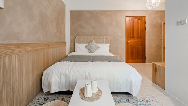 A bedroom with a bed, bedside table, and a door. - Apple Scent Easy Stay (Magong)