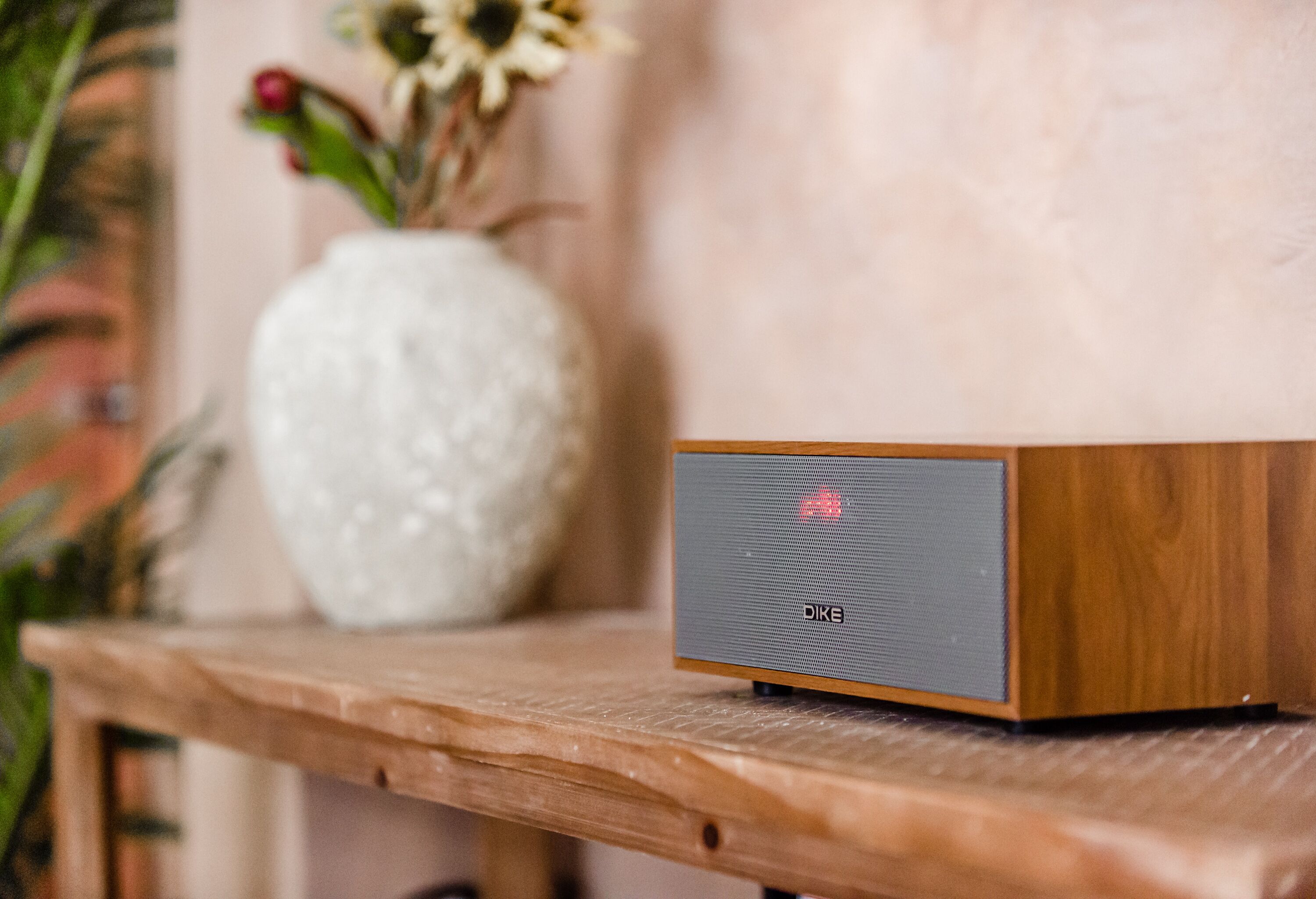 Una mesa de madera con un altavoz encima.