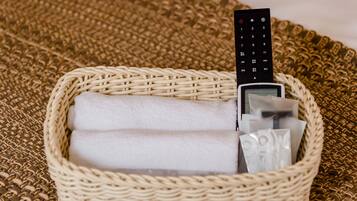 A wicker basket containing a remote control, a tissue, and a small item.