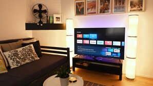 Una sala de estar con televisor, sofá y mesa de centro.