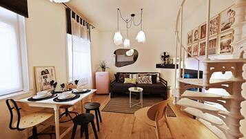 Een moderne woonkamer met een eethoek, een bank, een bijzettafeltje en een decoratieve spiegel.