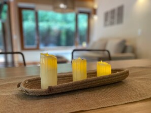 A tranquil ambiance is created with candles on a woven tray, set on a table.