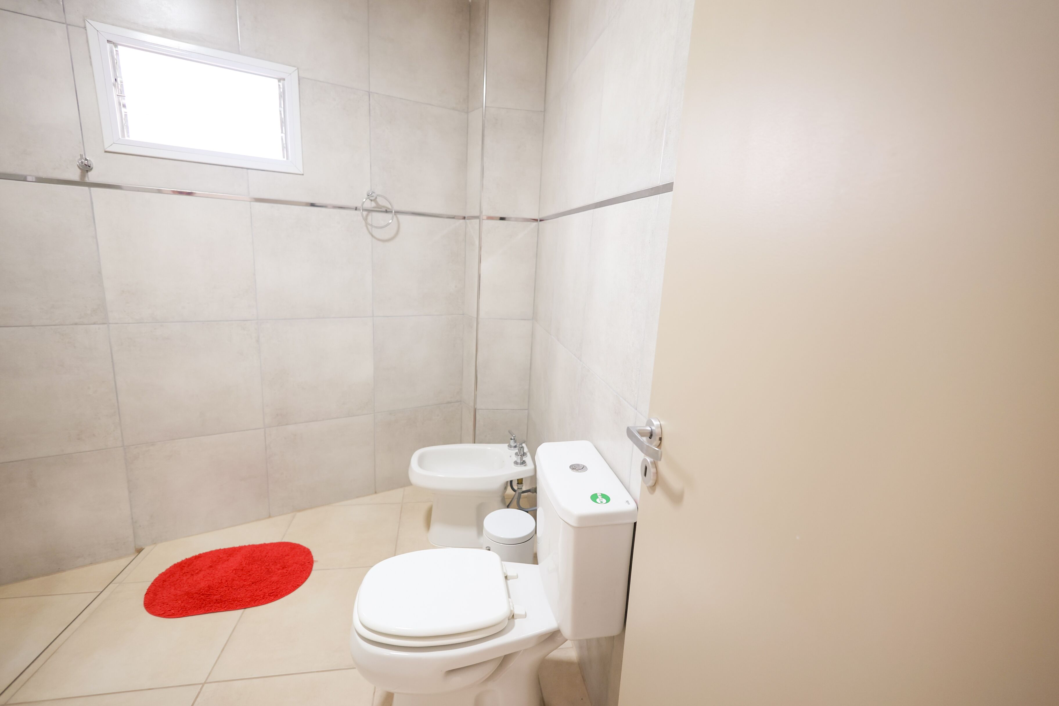 Een badkamer met een toilet, een bidet en een wastafel.