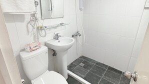 Een badkamer met toilet, wastafel en douche.