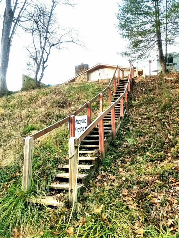Un escalier en bois mène à une maison portant l’inscription « Magnolia House ».
