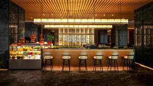 A modern bar area with a wooden slatted ceiling, a refrigerated display case with beverages, and bar stools.