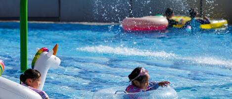 Piscina com brinquedos infláveis e um mastro verde.