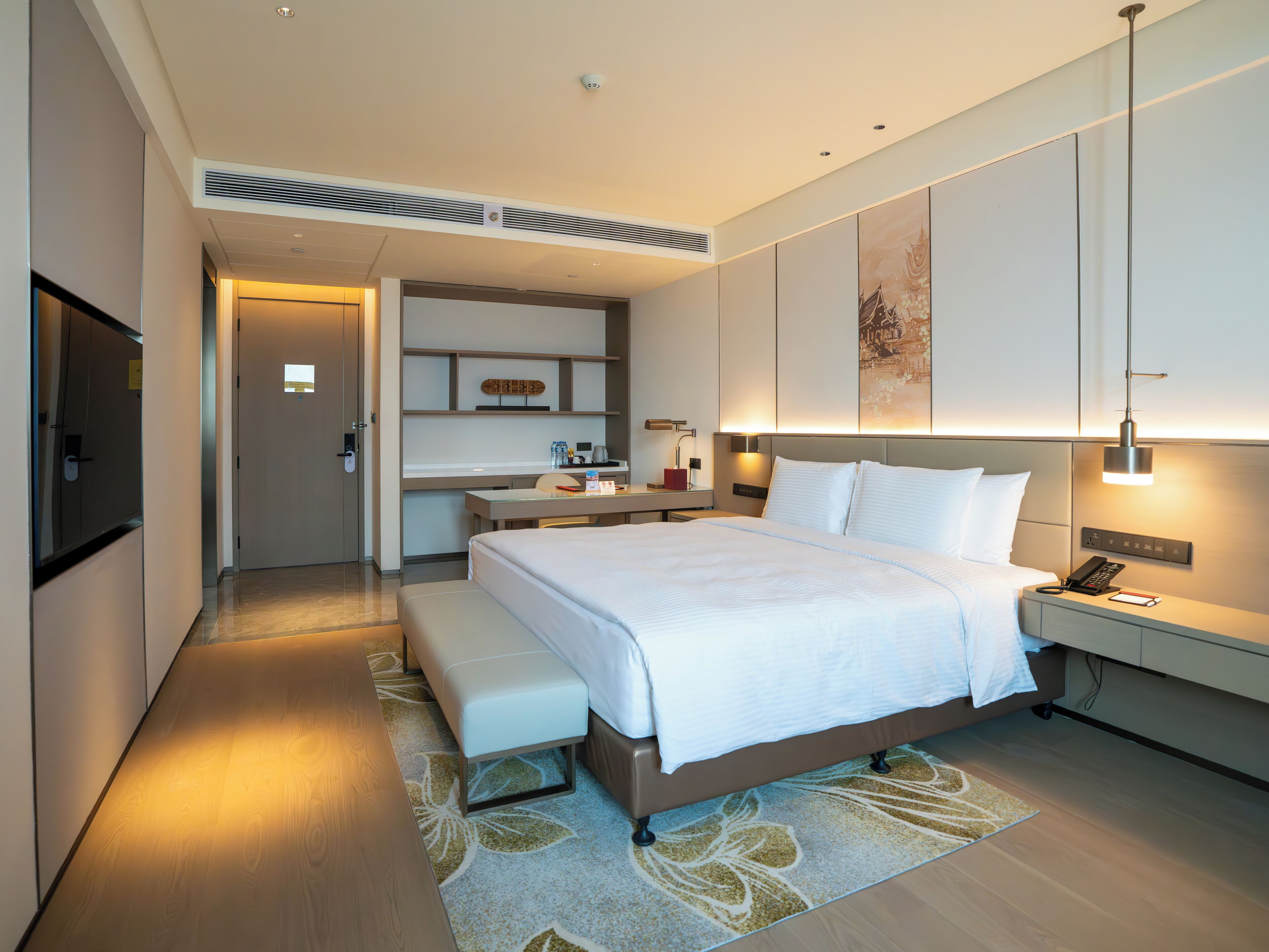Een moderne hotelkamer met een groot bed, een bureau en een bank.