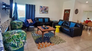 A living room with a sofa set, a coffee table, and a patterned rug. - A tropical paradise in the desert! (Cathedral City)