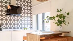 Une cuisine moderne avec un tabouret de bar en bois, un téléviseur suspendu et une fenêtre offrant une belle vue.