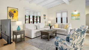 A living room with two sofas, a coffee table, and a TV. - 3BR 2BA Near Eagle Beach w/ Private Pool (Noord)