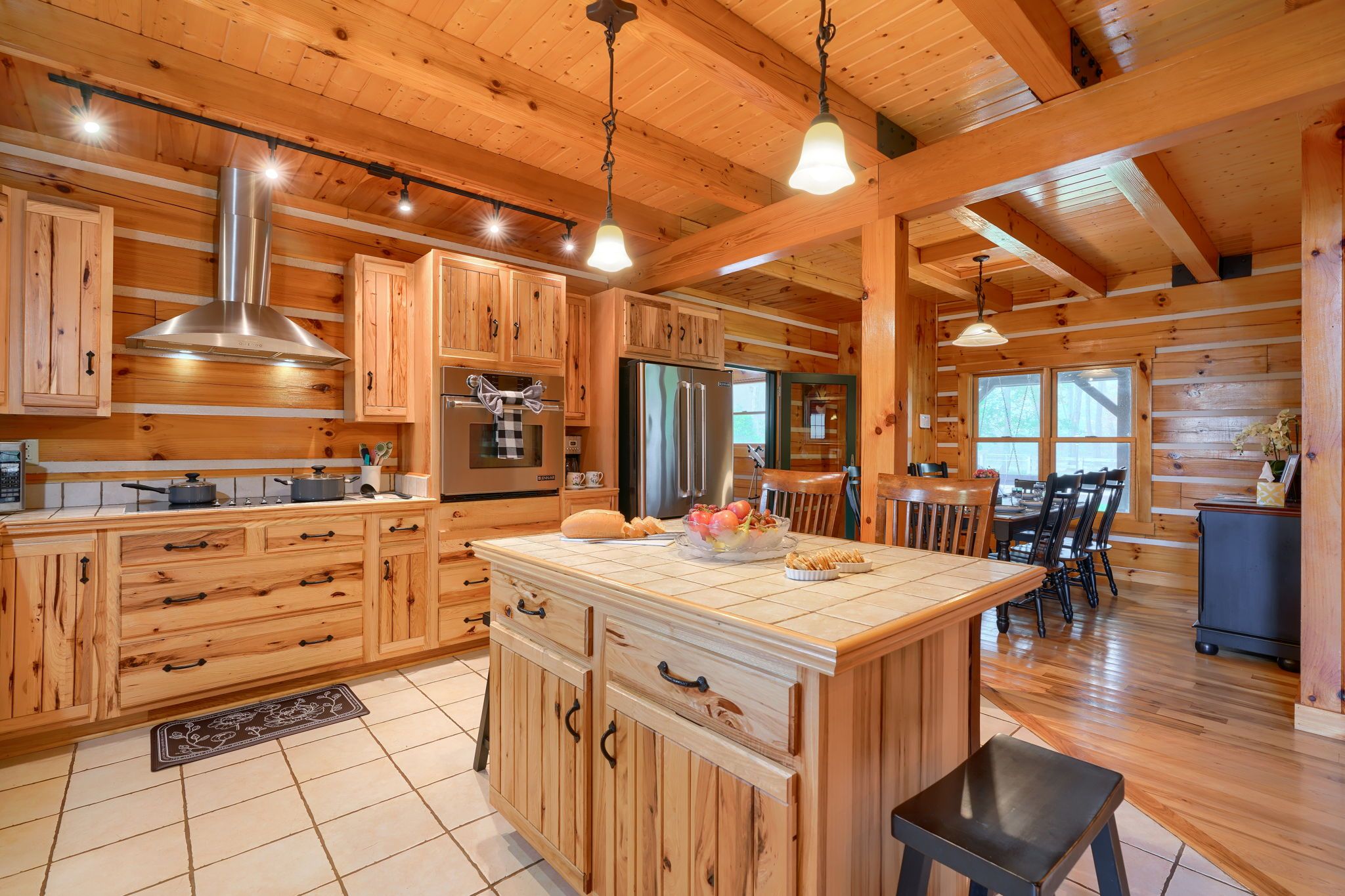 A spacious kitchen with wooden cabinets, a central island, and a dining area with a view.